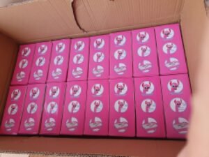Open cardboard box filled with 24 pink boxes, each featuring a white circular logo, arranged in a neat grid.