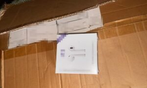 White box displaying AirPods packaging on a cardboard surface.