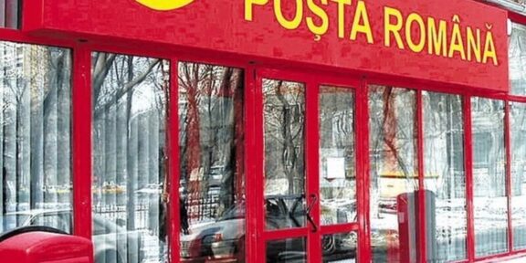 Front of a Poșta Română post office with a red facade, glass doors, and a red mailbox outside in the snow.
