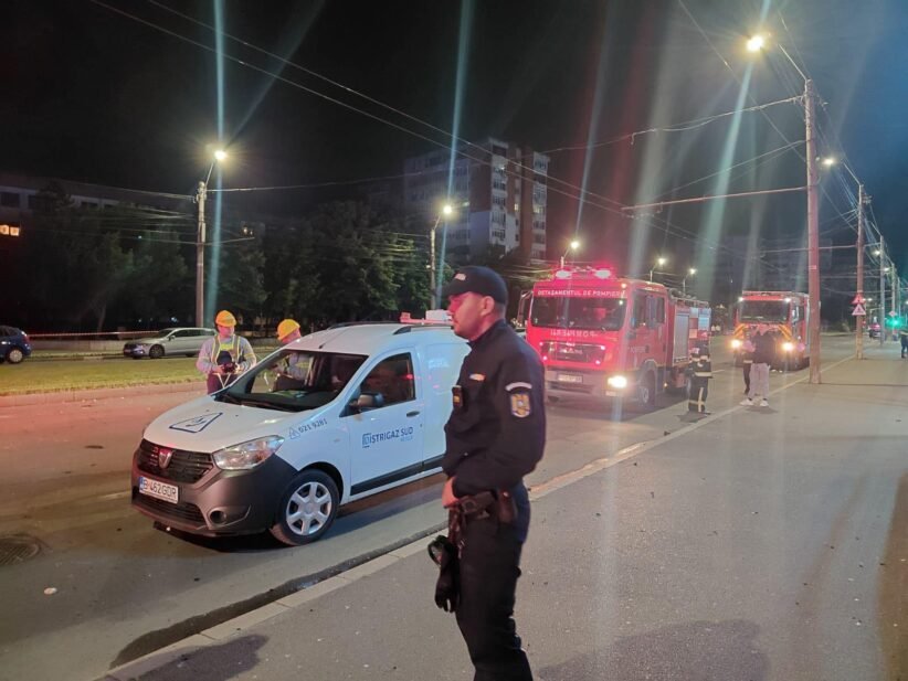 Night scene with a police officer in the foreground, a white Distrigas van, and red fire engines behind.