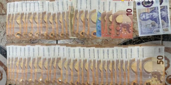 Seized euro banknotes arranged in two long rows on a patterned surface, with police logos in the corner.