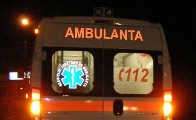Rear view of a white ambulance at night with orange stripes; 'AMBULANTA' on the back, a blue Star of Life logo, and '112' on the window.