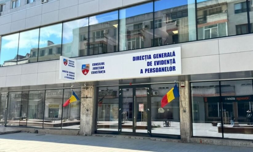 Front of a government building with Romanian flags and a blue sign reading 'Direcția Generală de Evidență a Persoanelor' above the doors (Constanța county office).